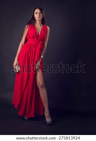 Sensual elegant young woman in red dress. Glamour woman. Modern woman in an evening cocktail red dress on a dark background. Party.