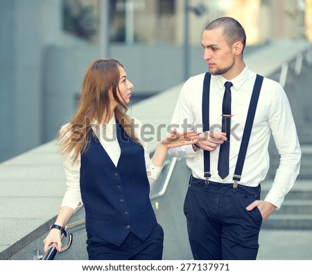 Business man and business woman. Business meeting. Two young business people at meeting. Working. Meeting with the client. Business people on the background of an office building.