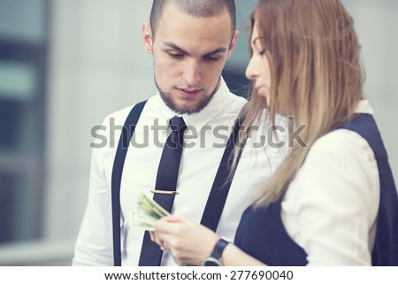 Business man looking for money the dollars are in the hands of a woman. Discuss financial issues. Affiliate work in the financial sector of the market. People discuss the amount of money available.
