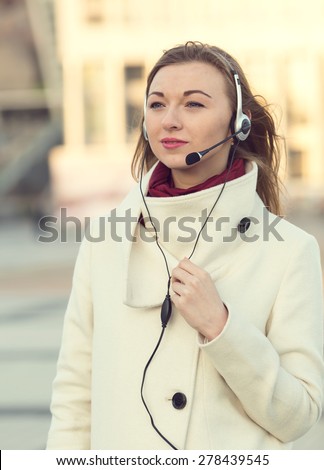 Portrait of happy smiling cheerful support phone operator in headset. Young female customer service operator. Business woman in headphones with a microphone for on line communication through Skype.