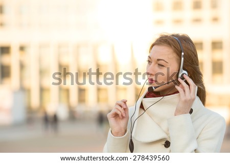 Portrait of happy smiling cheerful support phone operator in headset. Young female customer service operator. Business woman in headphones with a microphone for on line communication through Skype.