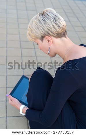 Woman with digital tablet in the city. European woman using tablet pc computer outdoor on a city street. Business woman with tablet pc in office district. Sad businesswoman. Student woman.