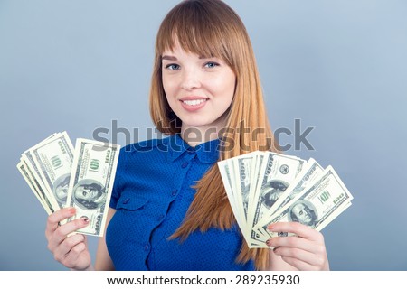 Young business woman holding money. Woman with hundred dollar bills in her hands. Deposit, profit, income, sale, bank, shop, win lottery - concept - smiling woman in blue dress with us dollar money.