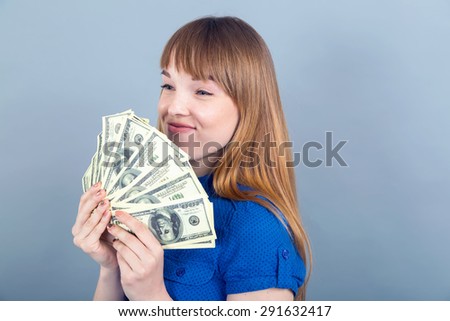 Portrait woman smell the money. She is smelling dollar banknotes on the blue background. Human emotion facial expression. Business lifestyle. Smell of money. hungry for money. Dreaming about shopping.