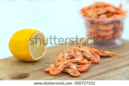 Shrimps. Sea products. Serving of cooked shrimp. Prepared shrimp on wooden blue background. Shrimp from the Black Sea. Snack to beer and wine. Delicious fresh cooked shrimp prepared to eat.