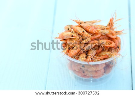 Shrimps. Sea products. One serving of cooked shrimp. Prepared shrimp on wooden blue background.