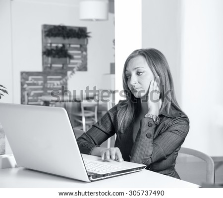 Stressed business woman. Business woman sitting in the office. Working using a laptop ps. Office people sitting at desk and working. Woman using laptop computer.