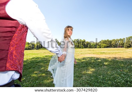 Follow me, follow me, marry! Wedding! Beautiful young woman bride holds the hand of a man in outdoors. Bride is the groom\'s hand. To go forward together. Bride and groom, who goes ahead. Just married.