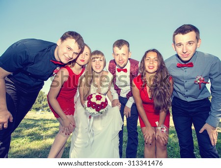 Bride and groom with friends. Just married. Group of young friends make selfie photo with smart phone camera in wedding day. Funny happy young people on the park. Wedding group of friends. Toned image