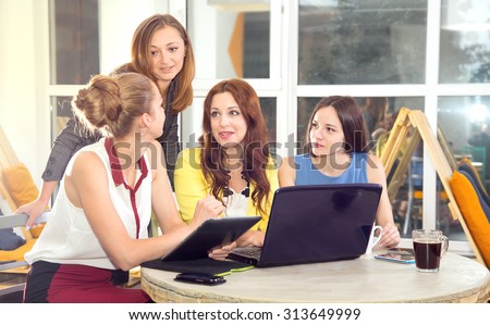 Working days in the women\'s team. Four young women - office staff. Discussion of joint work on the project. Female business. Women working in the office at the computer. Group of women. Toned image.