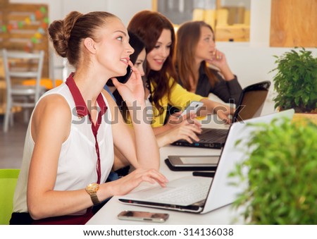 Working days. Women\'s team. Four young women - office staff. Joint work on the project. Woman business. Women working in the office at the computer. Group of women. Group of students. Toned image.