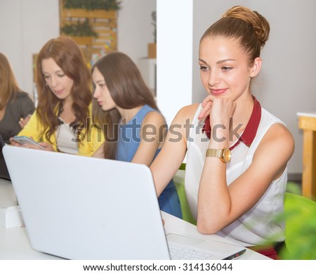 Businesswoman at workplace. Portrait beautiful woman on the background of modern business office. Young business woman working in office. Woman student look at the screen. Green office. Life style.