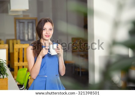 Beautiful woman drinking coffee in the morning at office. Take a break. Come early. Work late. Girl student holding a cup of coffee or tea.