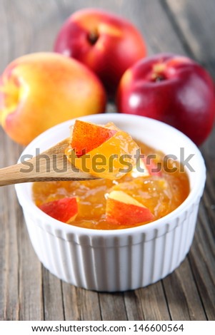 nectarine, peach jam on wood background