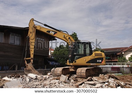 NONG KHAI, THAILAND - August 17, 2015: Tracked Excavator pull down the building to build a new house on August 17, 2015 at Mueang Nong Khai Municipality, Thailand