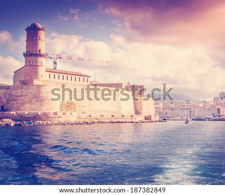 view of Fort St. Jean and the city of Marseille with the sea, on a background of a bright sunset sky