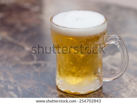 one mug of light beer on the table