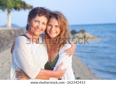 mother and adult daughter on the sea shore, family portrait