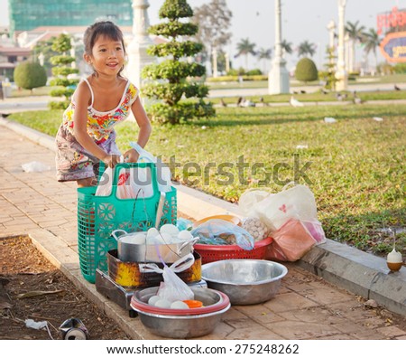 little girl selling food on the streets of Phnom Penh in Cambodia. Editorial image, January 27, 2015