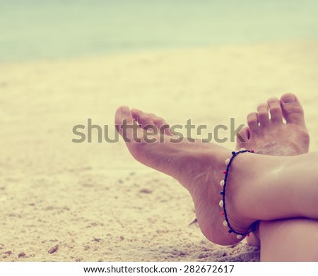 sandy feet on the beach, image with retro toning