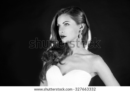 Black and white portrait, beautiful girl in a wedding dress with a gun, studio shooting