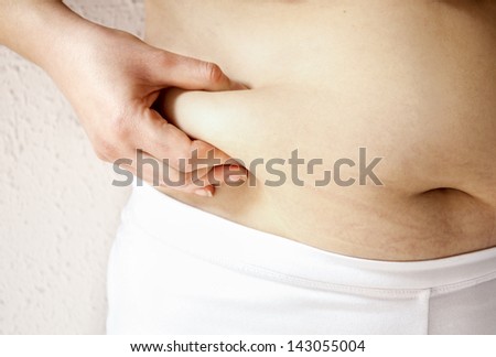 Close up of a obese  young lady checking her fats