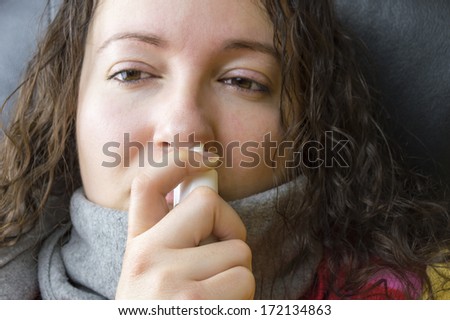 Woman using a nasal spray with focus on hand