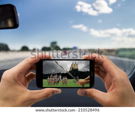 man traveling by car and seeing on your smartphone a medieval movie