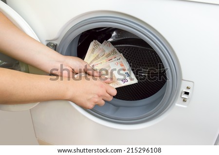 hand putting money into the laundry machine in  concept crime of Money Laundry