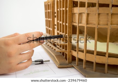 Close Up of an architect adding to his planning next to a miniature stadium