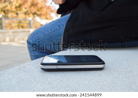 confident woman leaves the phone on the park bench