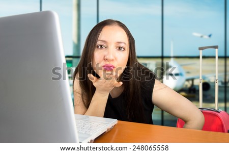 woman blowing a kiss at the airport after making a reservation tickets