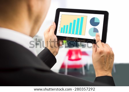 bussinesman looking at the stock market data on a tablet on the office.All screen content is designed by us and not copyrighted by others and created with wacom tablet and ps