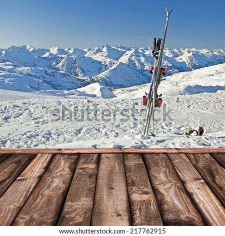 Wooden deck and pair of skis in the snow