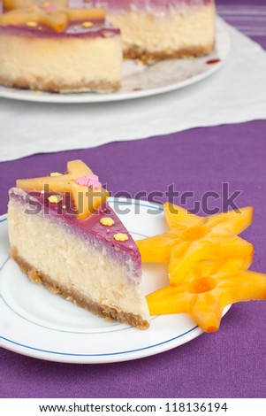Slice of delicious white chocolate cheese cake with a cake in the background
