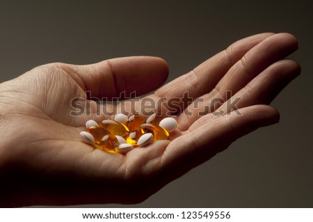 Closeup of  hand holding vitamin E and vitamin D capsules