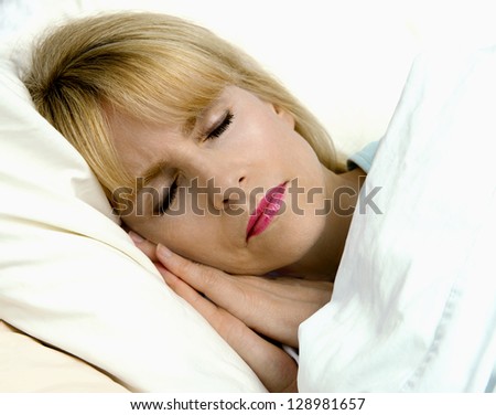 Pretty blond woman sleeping peacefully in bed