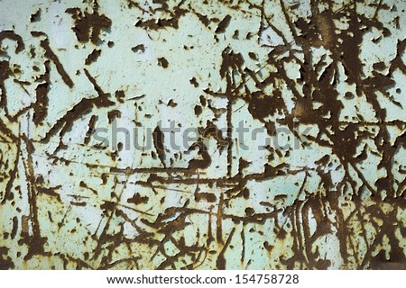 Detail of peeling paint and rust on exterior wall of abandoned factory