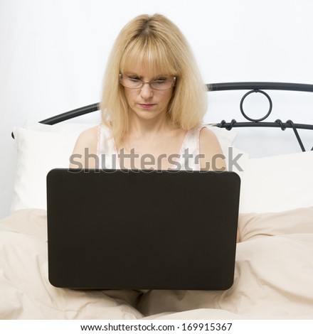 Middle age woman in bed using laptop computer