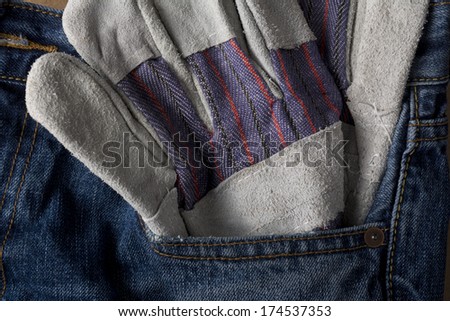 Work gloves stuck in blue jean pocket