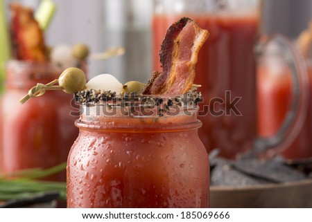 Table arrangement with pepper smoked bacon bloody mary or caesar in mason jars