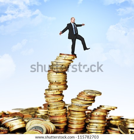 man try to balance himself on coin piles