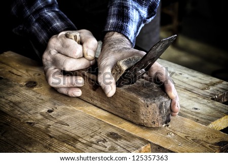 carpenter at work with vintage planer