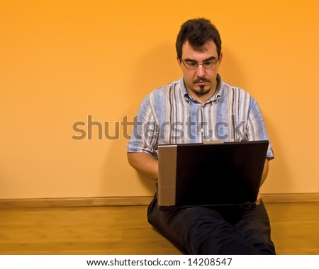 young man sit down on bamboo floor work with his laptop 02