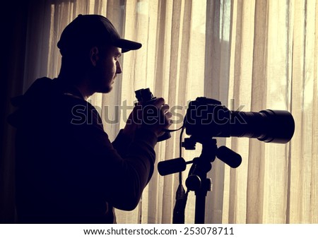 man with binoculars and camera control someone