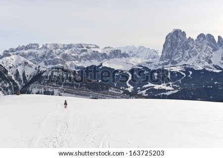 Person snowshoeing against wide Dolomites landscape