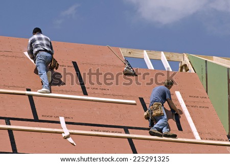 Horizontal Shot Of Workers On Roof/ Workers Are Not Identifiable