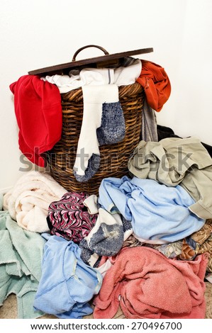 Horizontal Shot Of A Laundry Basket Spilling Out Onto The Floor With Dirty Clothes/ Time To Wash Some Dirty Laundry