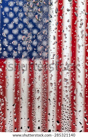 Vertical shot of An American flag photographed through water drops on glass, creating many tiny mirror images of the flag/ American Flag Under Wet Glass