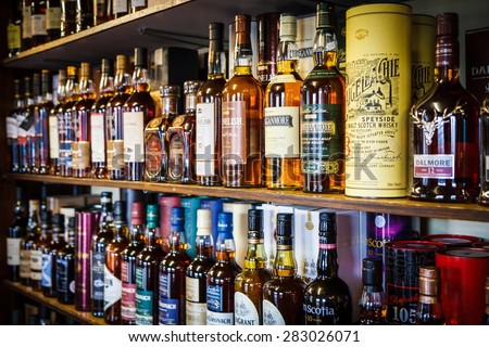 TOMINTOUL, UK - MAY 16: Various bottles of Scotch whisky on the shelf on May 16, 2015 in Tomintoul, UK. Scotch whisky must be made in a manner specified by law.
